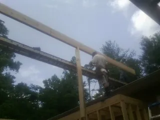 Carpenter setting a ridge beam over a new addition frame — Ice Dam Removal by Roofing Brothers in Los Banos
