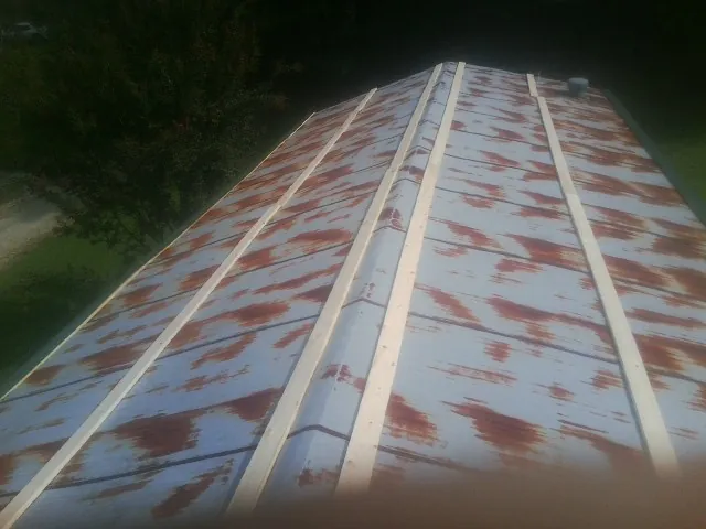 Rusted metal roof panels with new wood purlins before replacement — Storm Damage Roof Repair in Los Banos by Roofing Brothers