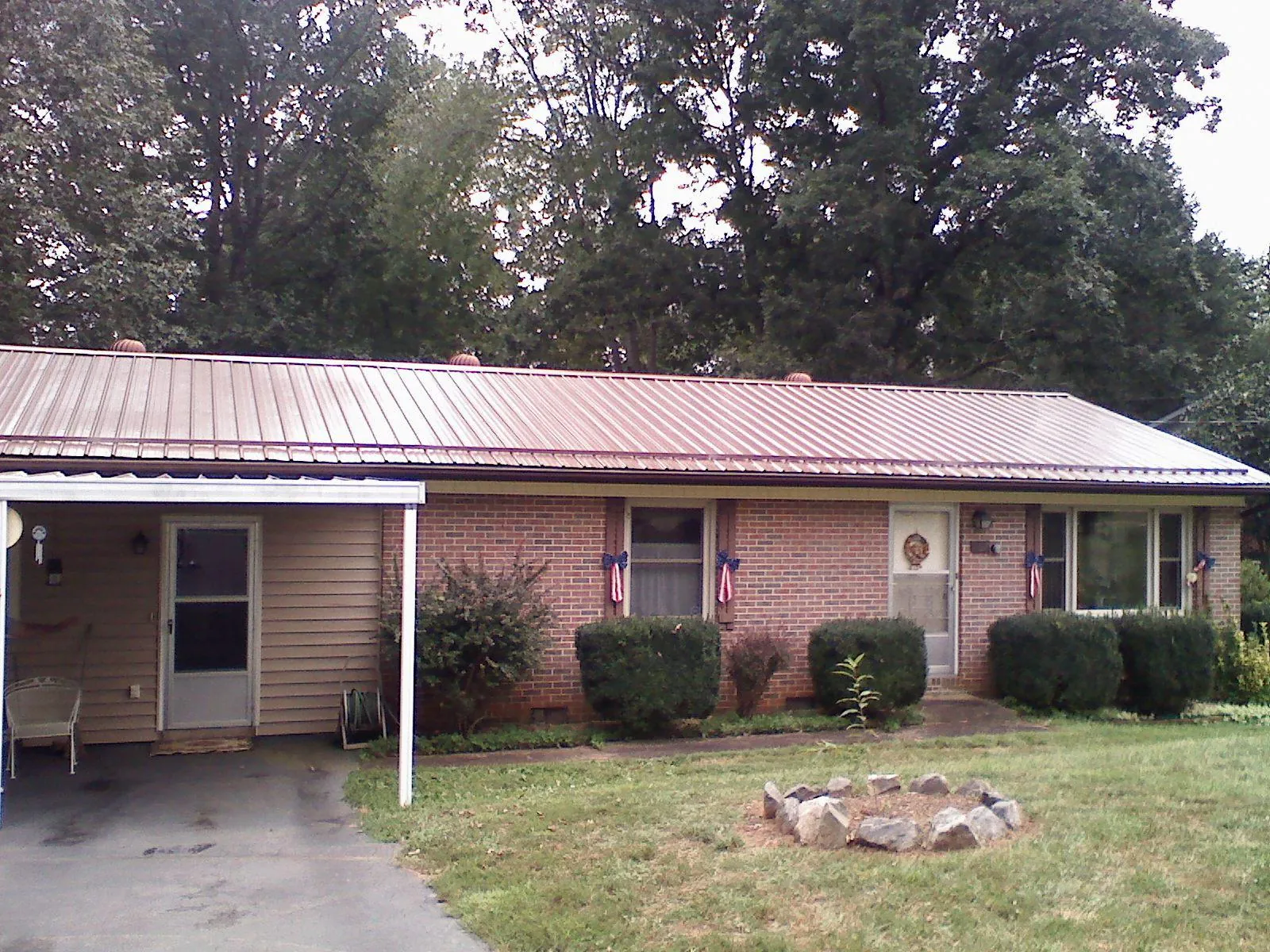 Bronze metal roof and carport on a brick ranch home — Roof Repair work by our crew in Los Banos