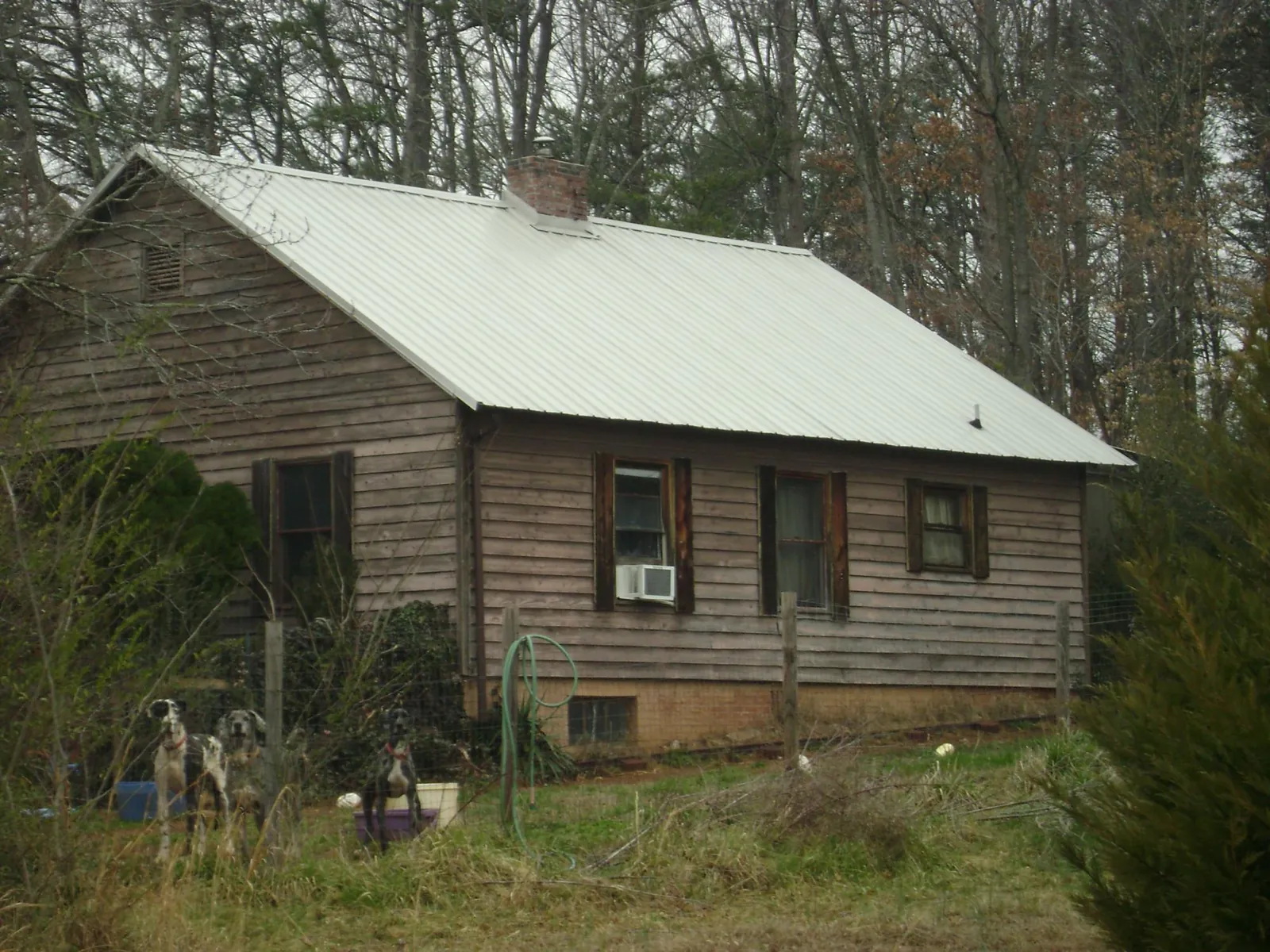 White metal roof on an old wood sided farmhouse, from a Metal Roof Installation job in Los Banos